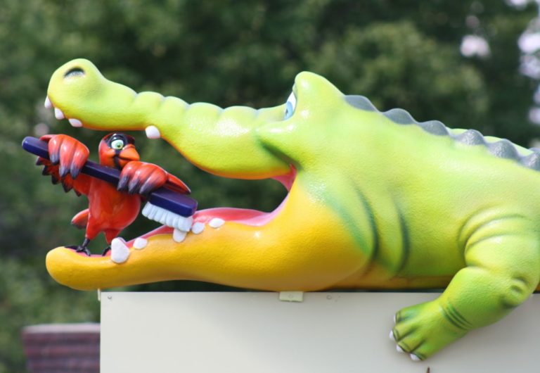 Statue of crocodile having a pediatric dentistry appointment.